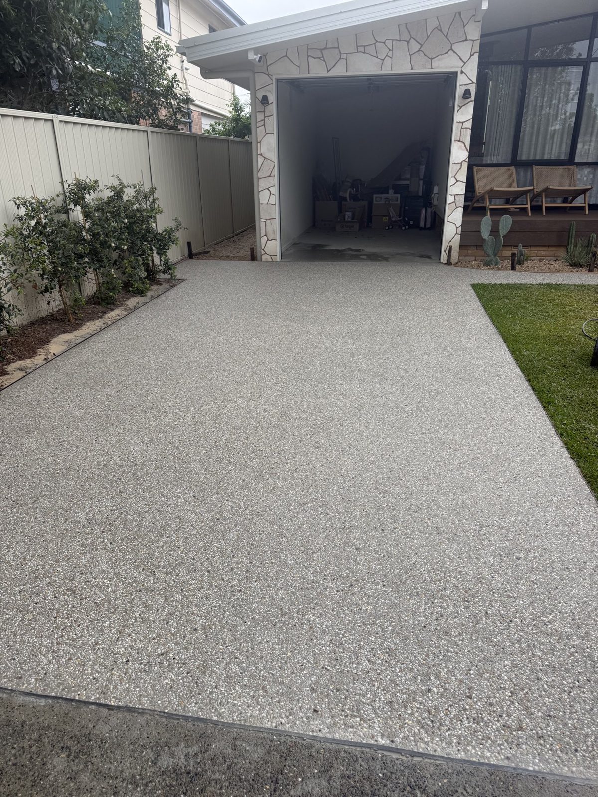 Exposed aggregate concrete driveway at a brick home by EAB Concreting, Hunter Valley