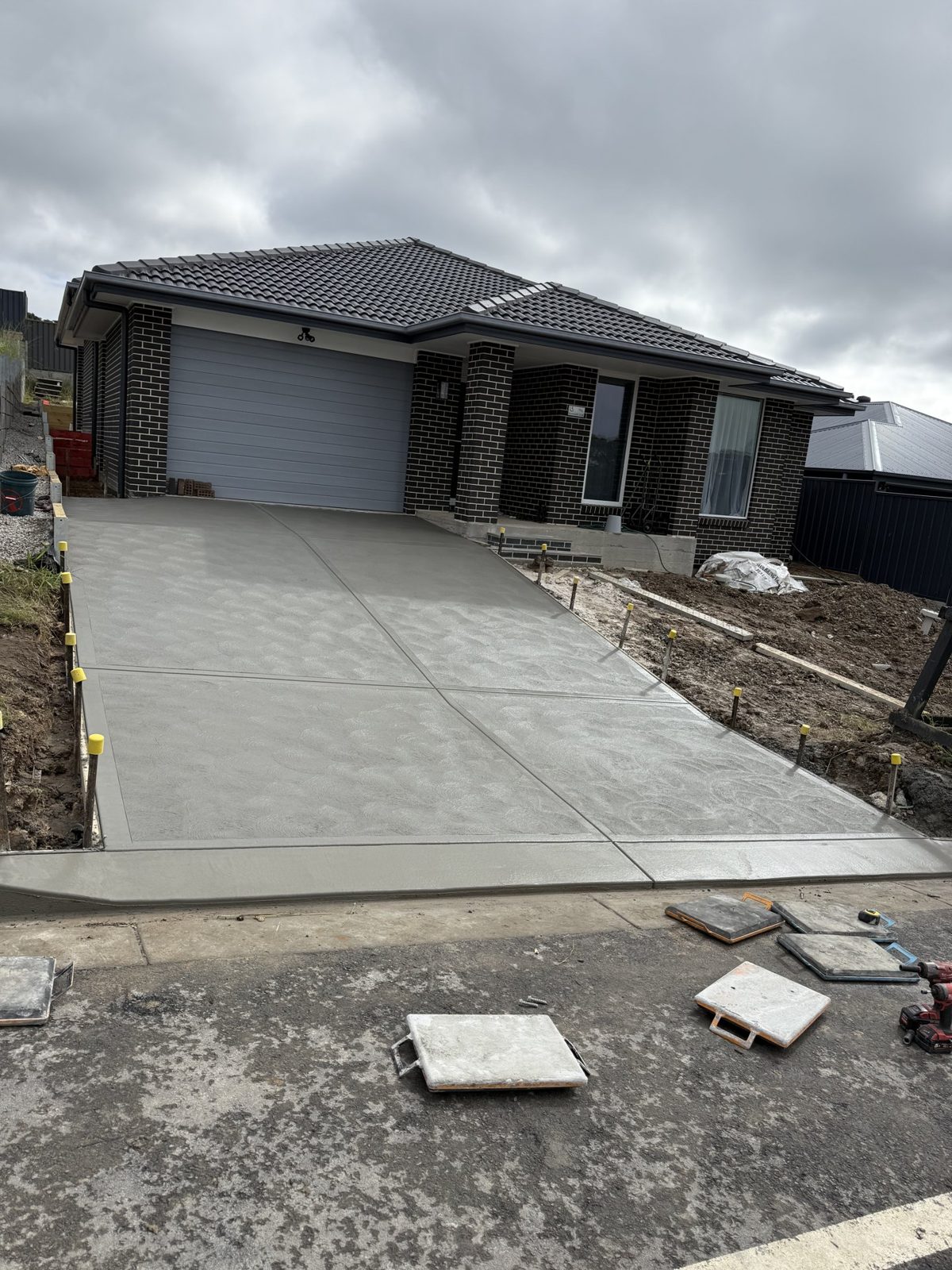 Plain concrete driveway at a new home by EAB Concreting, Hunter Valley