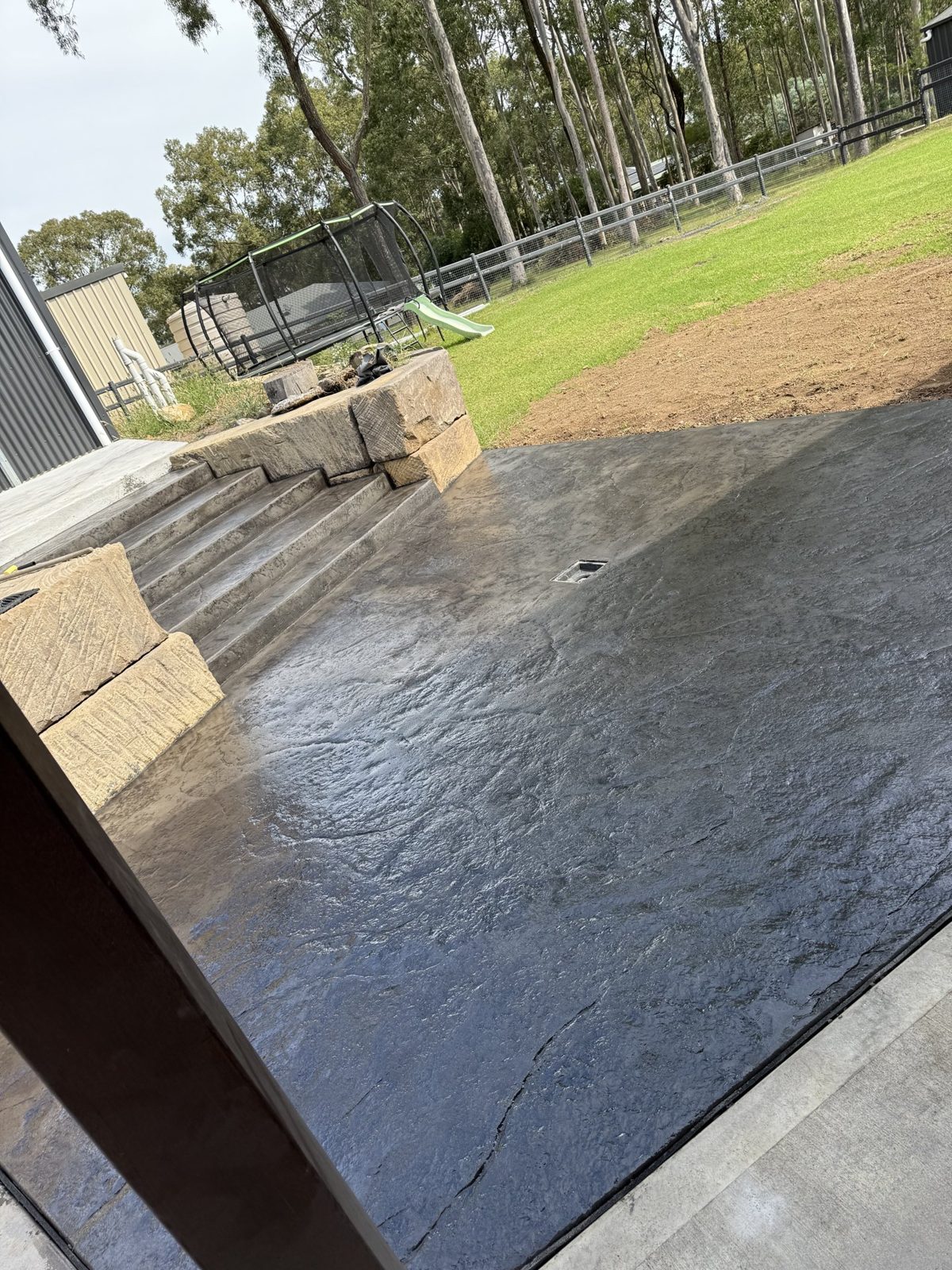 Stamped concrete patio with sandstone-look steps by EAB Concreting, Hunter Valley