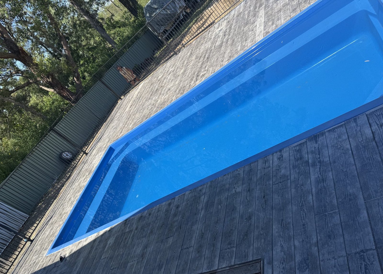 Wide view of a timber-look stamped concrete pool surround by EAB Concreting, Hunter Valley